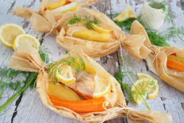 Fisch mit Zitrone, Dill und Gemüse wie ein Bonbon eingepackt in Backpapier.