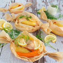 Fisch mit Zitrone, Dill und Gemüse wie ein Bonbon eingepackt in Backpapier.