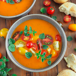 Tomatensuppe rustikal angerichtet auf Holzuntergrund